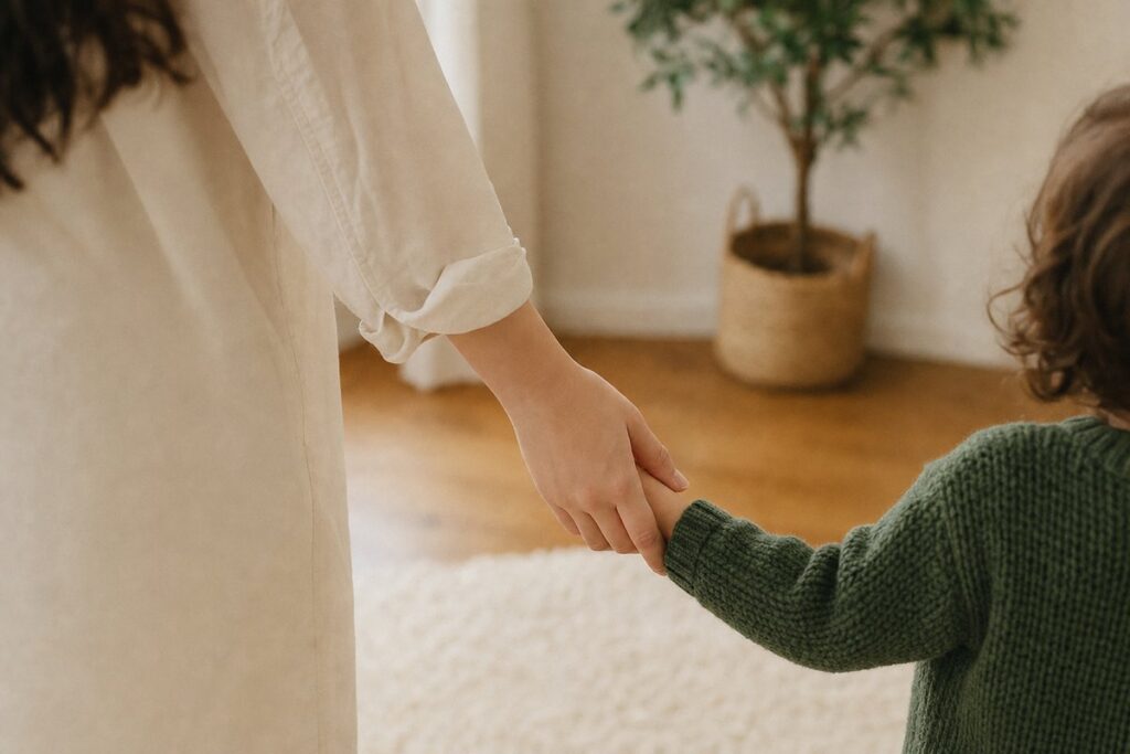 Eine erwachsene Hand reicht behutsam einem Kind die Hand – Geborgenheit statt Klinik in der Kinderpflege